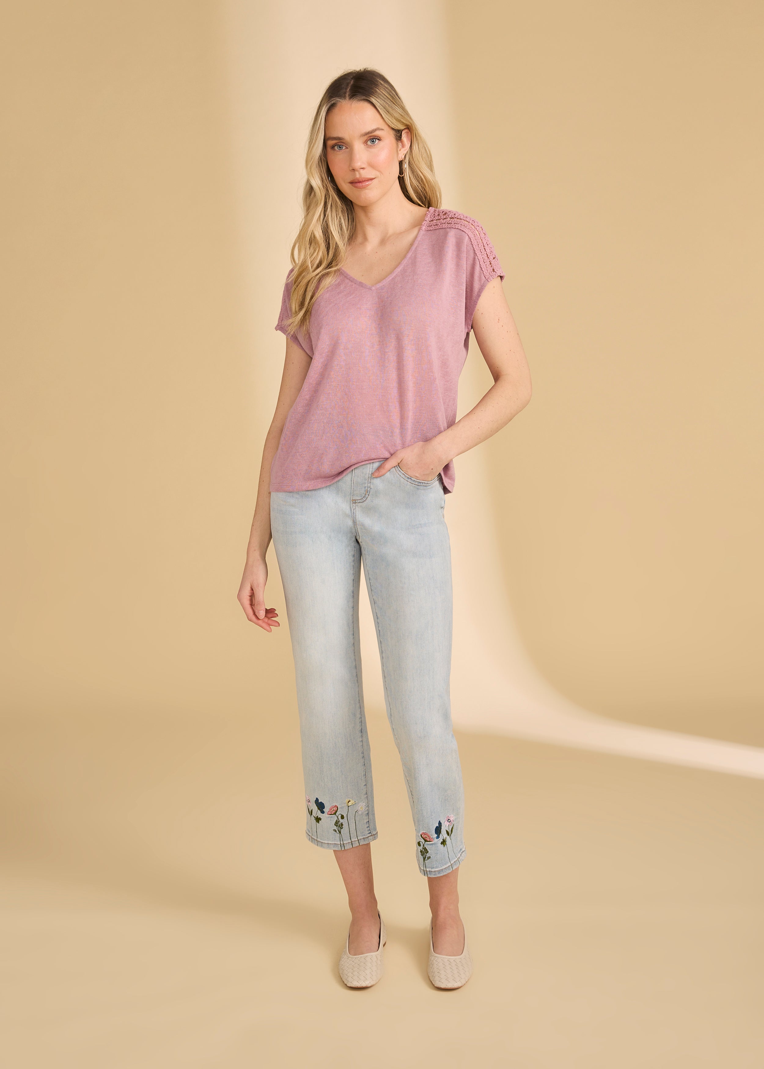 Full view of pink V-neck top paired with embroidered jeans and flats by French Dressing Jeans (FDJ)
