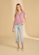 Full view of pink V-neck top paired with embroidered jeans and flats by French Dressing Jeans (FDJ)