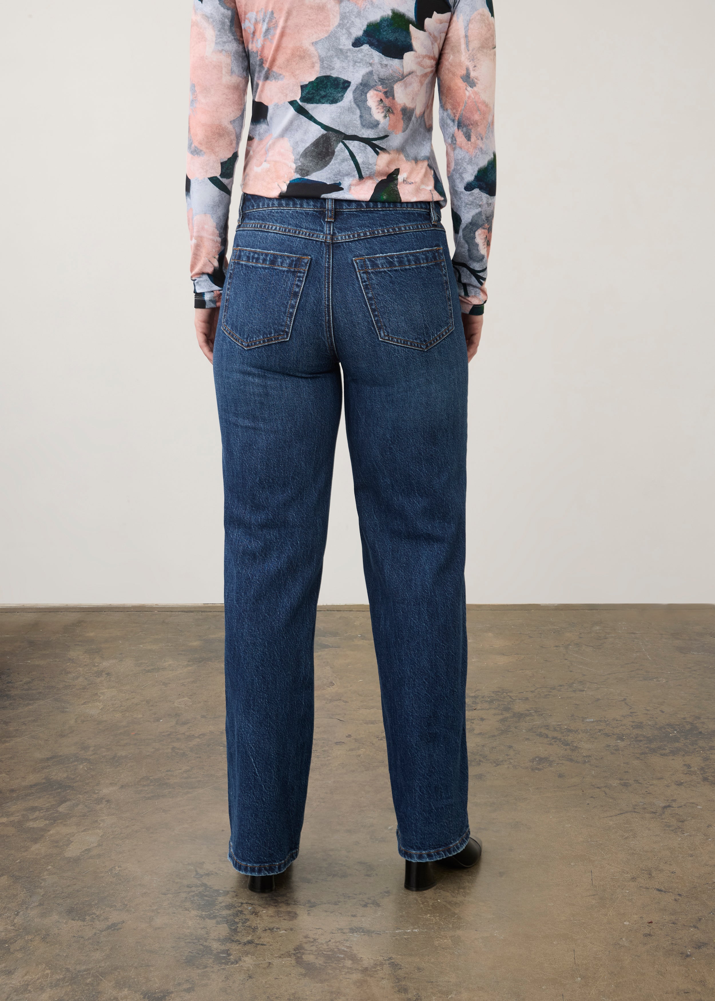 Back view of dark wash jeans with floral top, showcasing back patch pockets by French Dressing Jeans (FDJ) par French Dressing Jeans (FDJ)