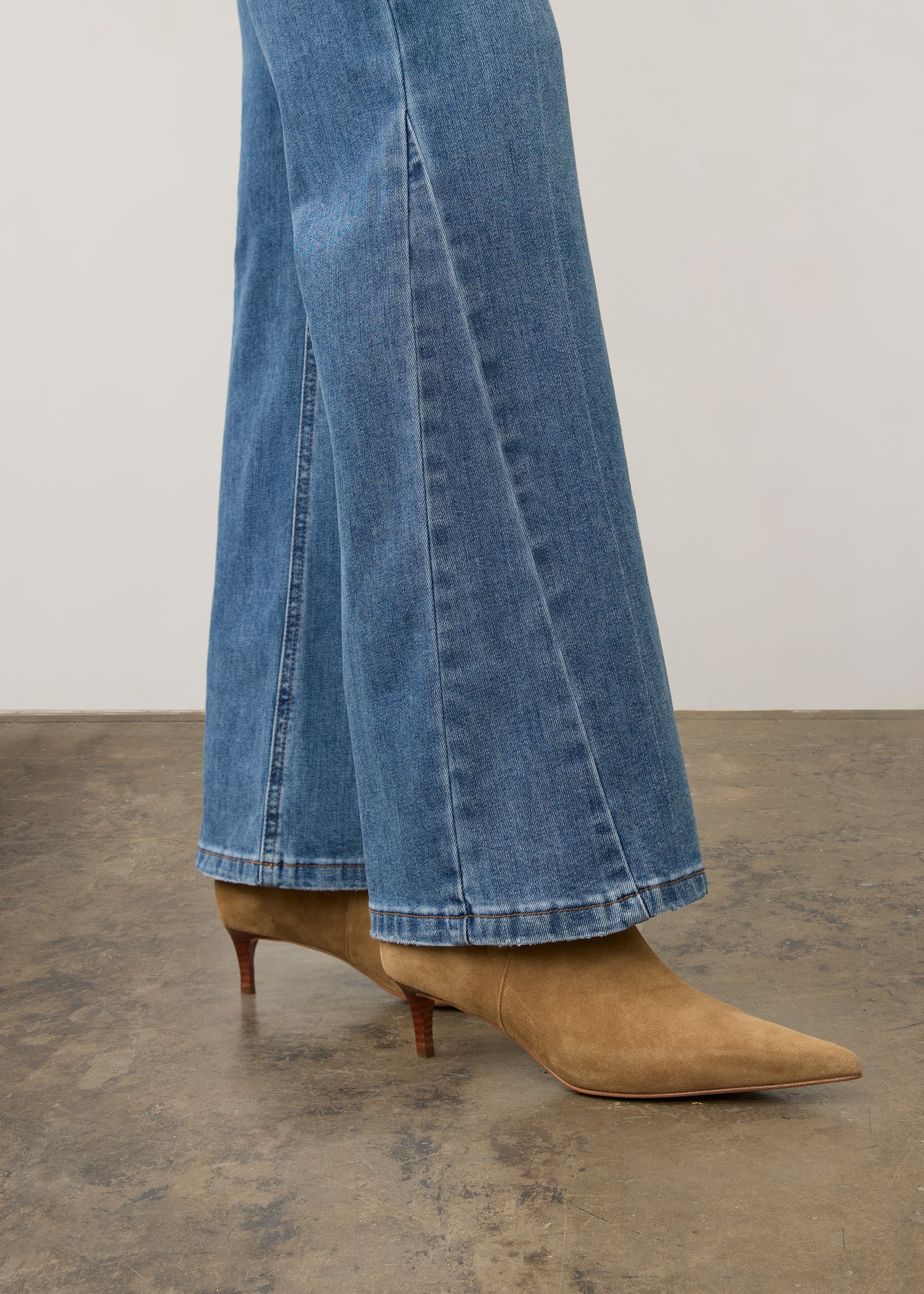 Side view of medium wash denim pants highlighting bootcut design and hem details by French Dressing Jeans (FDJ) par French Dressing Jeans (FDJ)