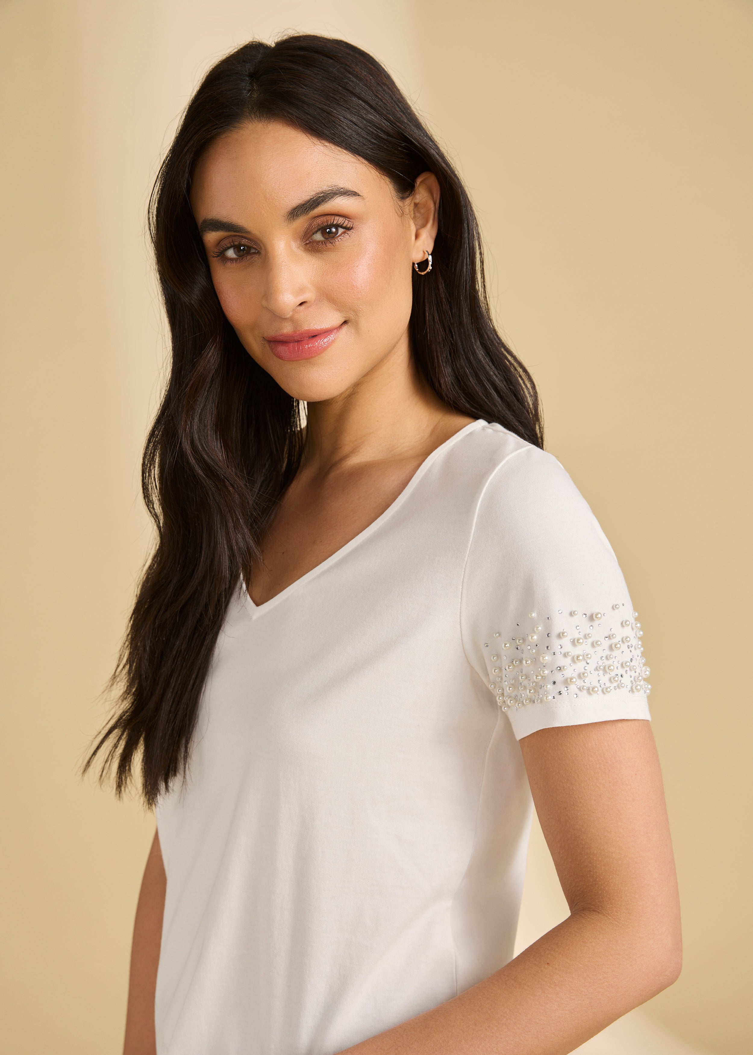 Close-up side view of white V-neck top highlighting pearl details on sleeves by French Dressing Jeans (FDJ)