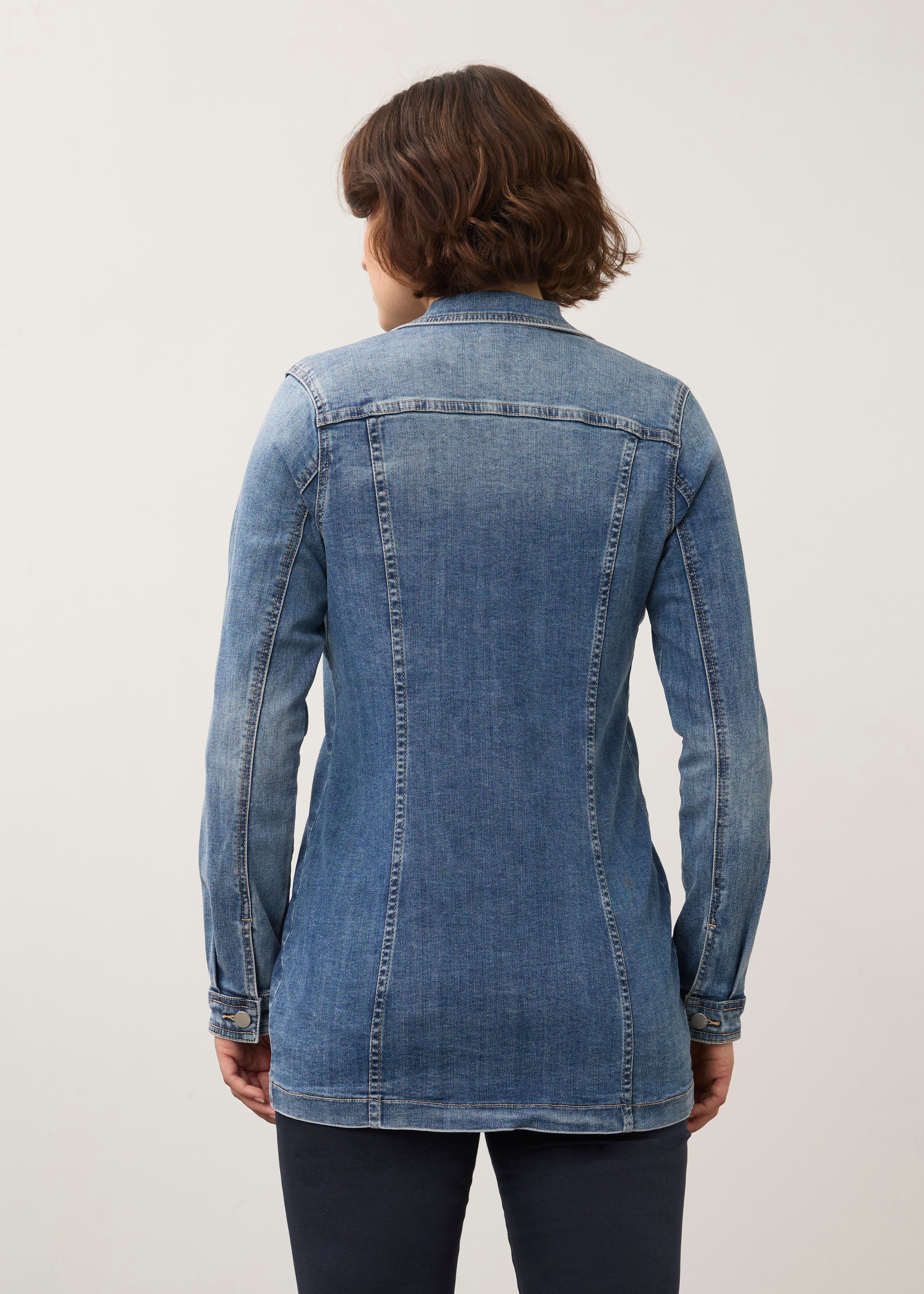 Back view of medium wash denim jacket showcasing seam detailing and long length by French Dressing Jeans (FDJ) par French Dressing Jeans (FDJ)