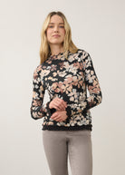 Front view of floral black top with scalloped edges, paired with gray jeans by French Dressing Jeans (FDJ)