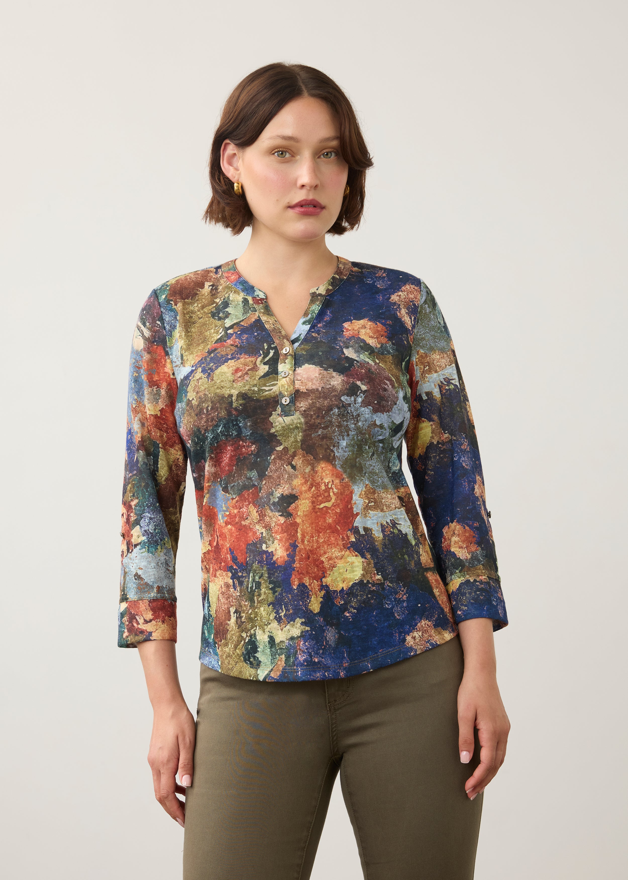 Front view of 3/4 sleeve Henley top in multicolor print, button-front, paired with olive pants by French Dressing Jeans (FDJ)