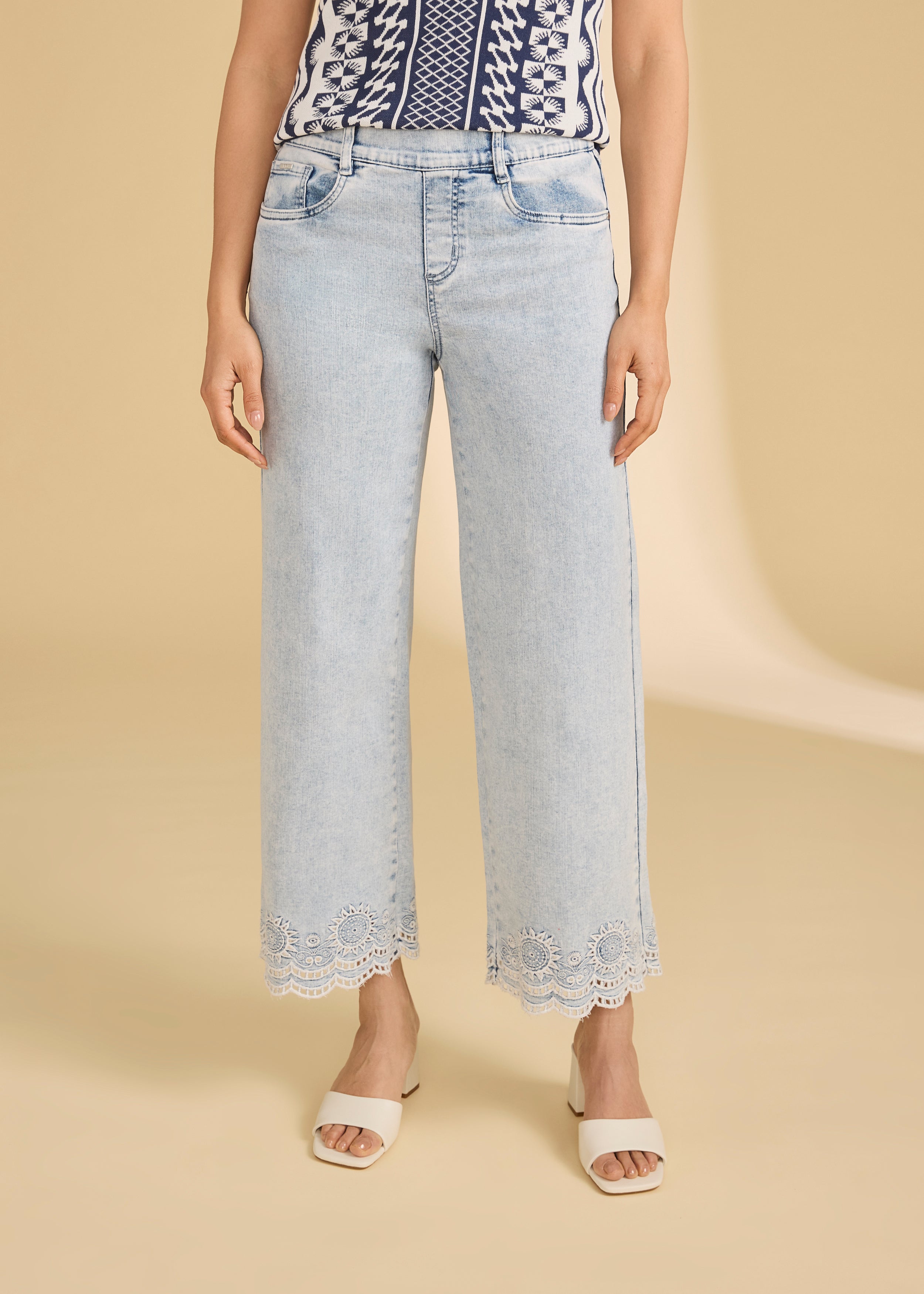 Woman wearing light medium pull-on wide ankle denim front view with lace hem detail by French Dressing Jeans (FDJ)