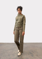 Full-length view of model in olive sweater with button accents and matching pants by French Dressing Jeans (FDJ)