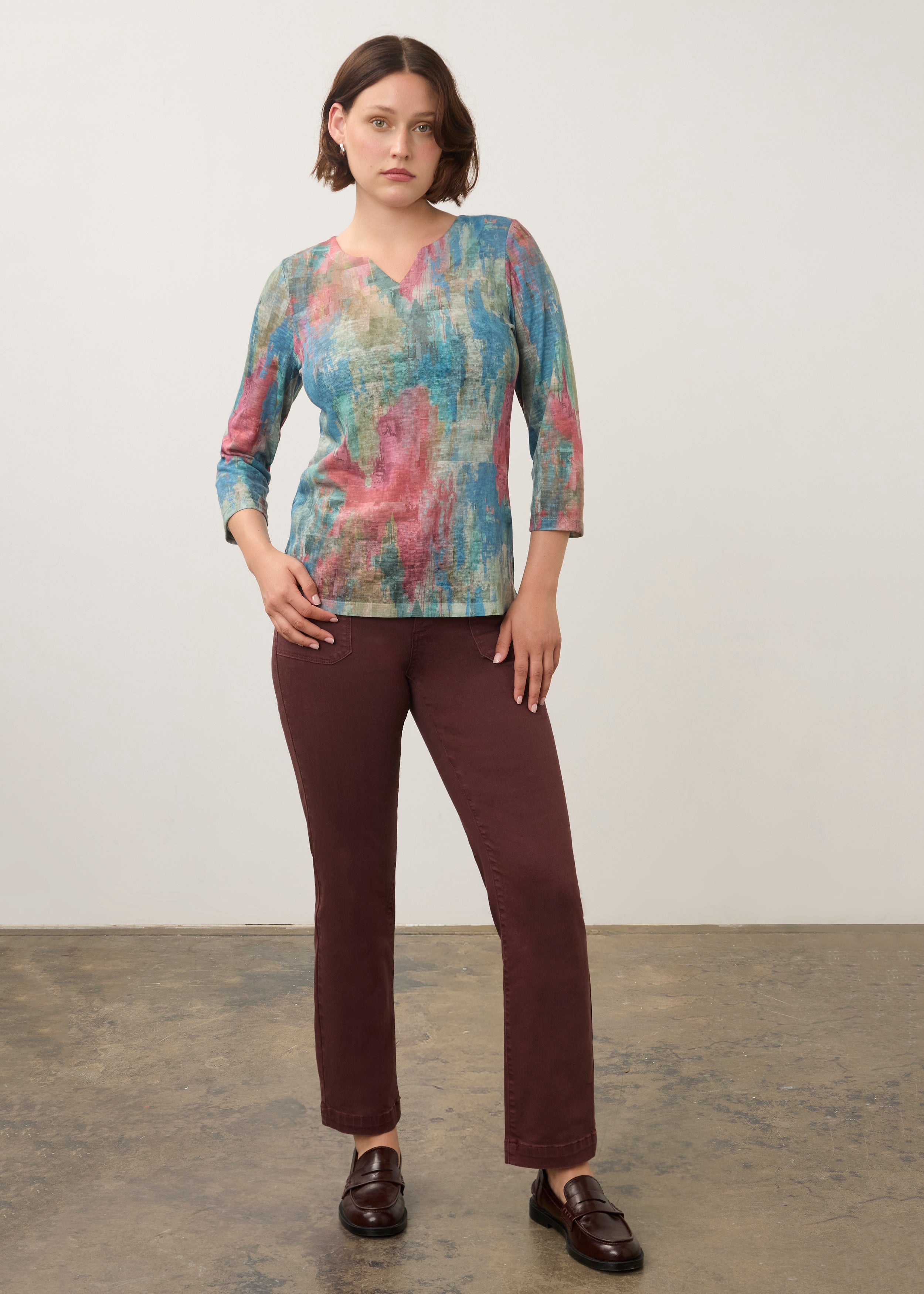 Full body view of pastel Henley top paired with burgundy pants and loafers by French Dressing Jeans (FDJ)