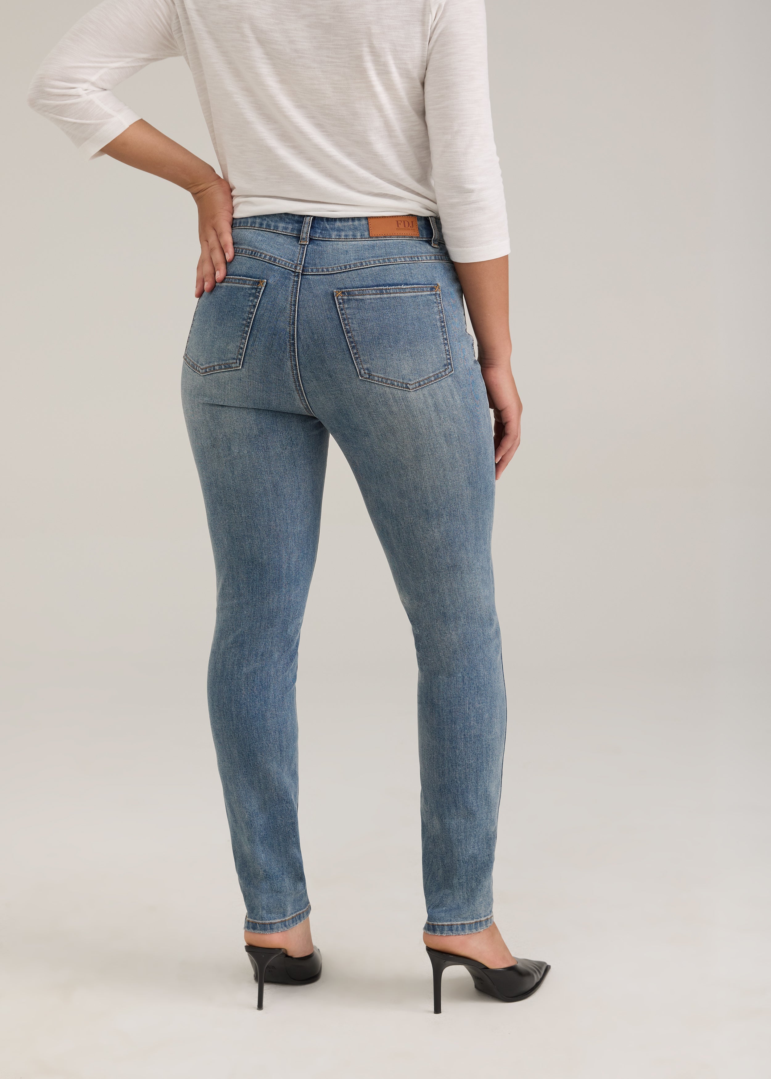 Back view of light wash jeans with back patch pockets and FDJ label by French Dressing Jeans (FDJ)