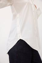 Side detail of white shirt showing curved hem and buttoned sides by French Dressing Jeans (FDJ)